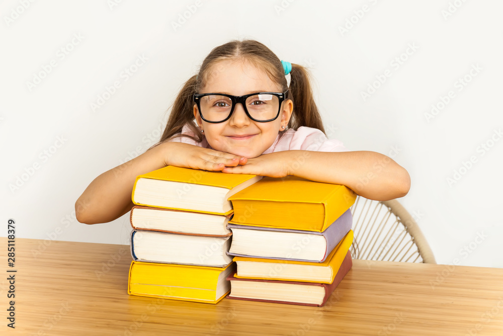 Smiling little student girl with many books at school Smiling little student girl with many books at school