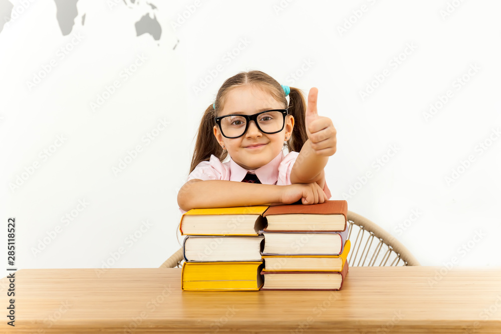 little girl with a lot of closed books gesturing thumb up little girl with a lot of closed books gesturing thumb up