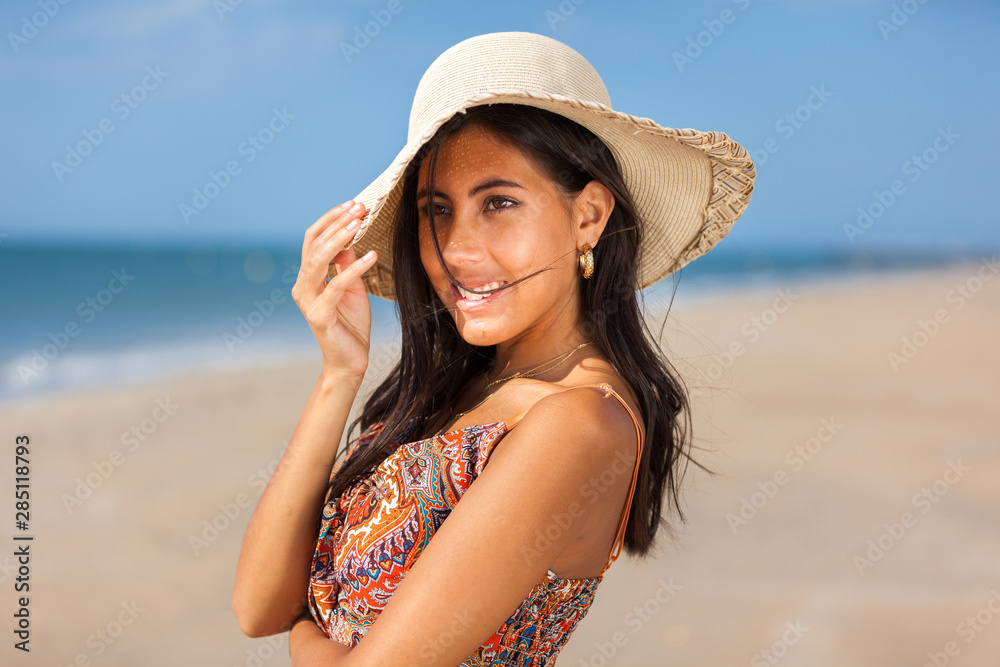 Portrait fashion of pretty young woman with straw hat on a beach. Happy Smiling girl..