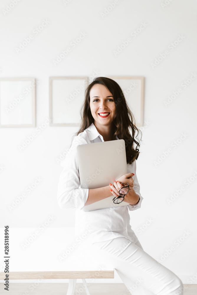 Young woman sitting on table with laptop