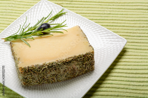 Cheese collection, one piece of Spanish manchego sheep cheese with rosemary herb