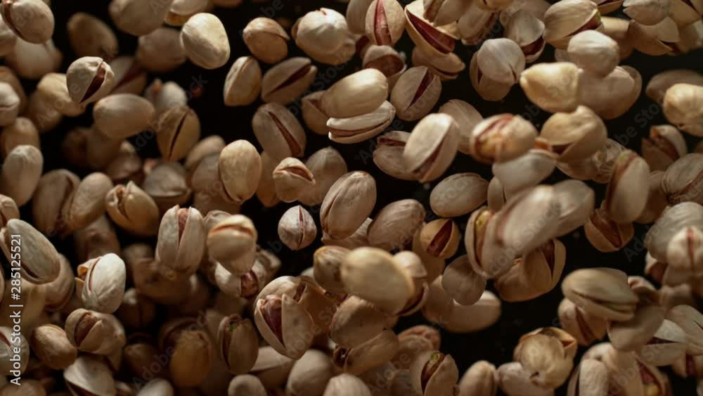 Super Slow Motion Shot of Pistachios Flies After Being Exploded against Black Background, 1000fps. Shooted with High Speed Cinema Camera at 4K. Super Slow Motion Shot of Pistachios Flies After Being Exploded against Black Background, 1000fps. Shooted with High Speed Cinema Camera at 4K.
