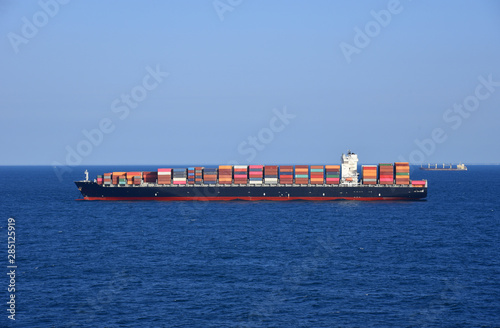 Cargo container ship loaded with containers during her voyage through the ocean. 