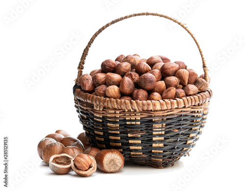 Small basket full of hazelnut kernels isolated on white