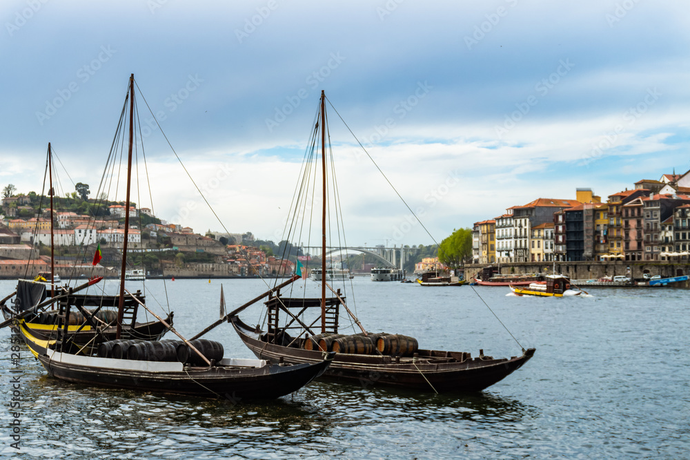 Typical portuguese boats transporting wine barrels on the river Douro in Porto