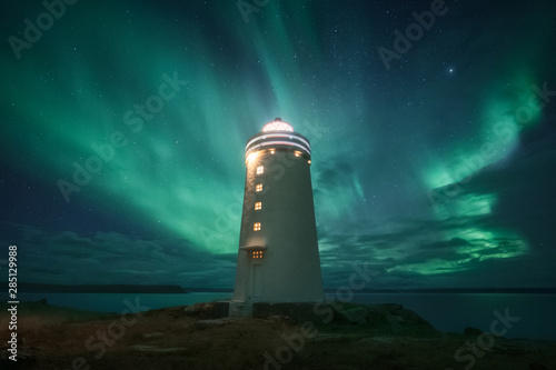 Amazing beacon with bright light located against wonderful starry sky in beautiful winter countryside