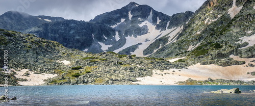 Panorama of Rila mountain lake and Musala summit on a misty, snow covered landscape