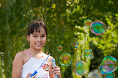 Girl and soap bubbles outdoor at sunrise