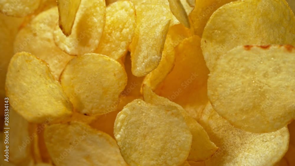 Super Slow Motion Shot of Potato Chips Flies After Being Exploded against Black Background, 1000fps. Shooted with High Speed Cinema Camera at 4K. Super Slow Motion Shot of Potato Chips Flies After Being Exploded against Black Background, 1000fps. Shooted with High Speed Cinema Camera at 4K.