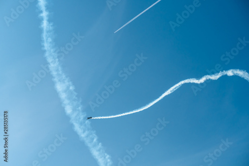Traces of airplanes in the sky. Elements of aerobatics on a sports plane.