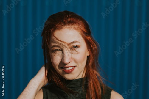 Smiling woman squinting in sun and enjoying weather photo