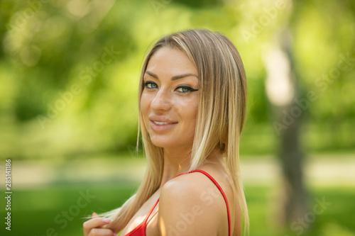 Young smiling woman outdoors portrait. Soft sunny colors. Summer portrait of a beautiful young blonde outdoors in the city.