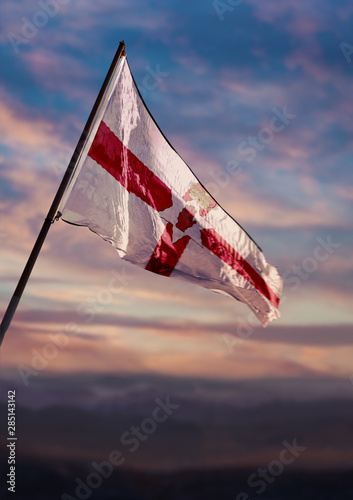 Northern Ireland flag, Irish flag waving on sky at dusk