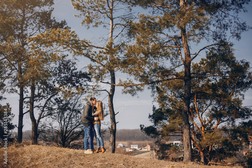 Cute couple in a park. Man with his wife. Lady with long hair Cute couple in a park. Man with his wife. Lady with long hair