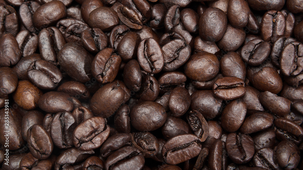 Fototapeta premium Roasted coffee beans background. Macro photography of coffee beans.
