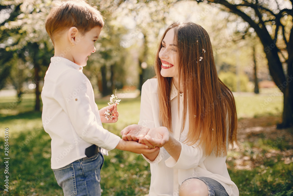 Fototapeta premium Family in a summer park. Mother in a white shirt. Cute little boy