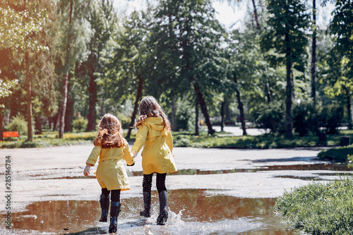 Fototapeta Naklejka Na Ścianę i Meble -  Kids in a rain coats. Children in a park.