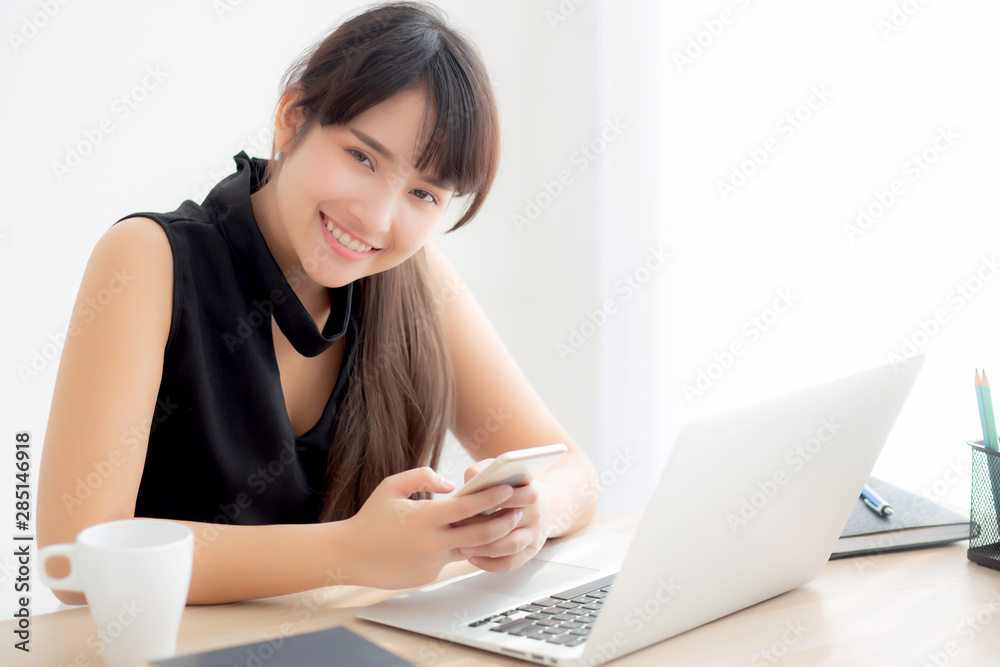Beautiful young asian woman working laptop computer online to internet and texting message on smart mobile phone, freelance using notebook, business and communication concept. Beautiful young asian woman working laptop computer online to internet and texting message on smart mobile phone, freelance using notebook, business and communication concept.