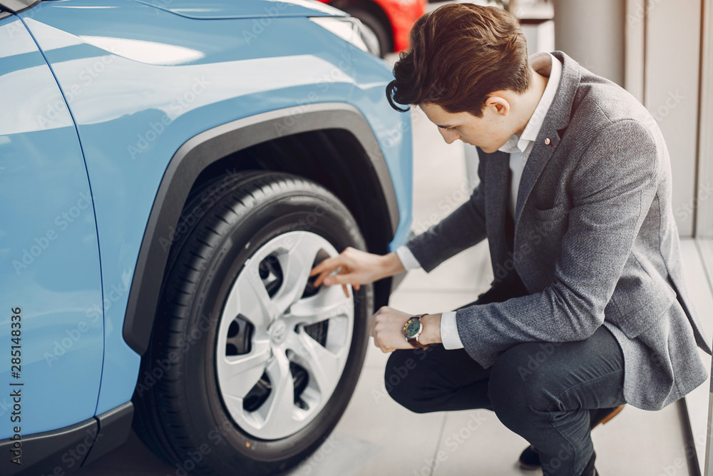 Man buying the car. Businessman in a car salon