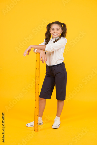 Exploring stem. Geometry school subject. School adorable student study geometry. Kid school uniform hold ruler. Education and school concept. Sizing and measuring. Pupil cute girl with big ruler