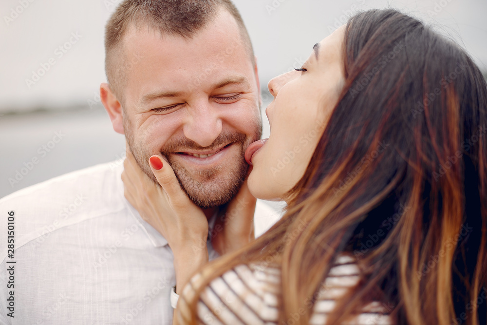 Fototapeta premium Couple in a park. Woman with long curly hair. Man with his wife