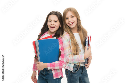 Back to school on September 1. Adorable little girls holding school exercise books. Small school children with note books. Ideal books to take to school for a wide variety of subjects