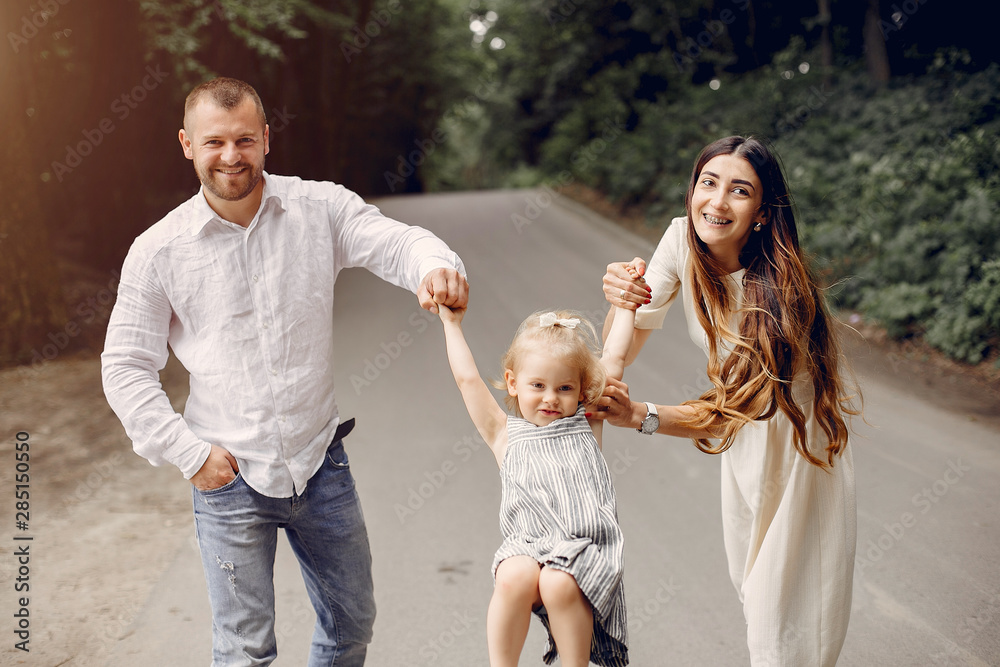 Fototapeta premium Family in a summer park. Mother and little daughter playing. Cute little girl with a father