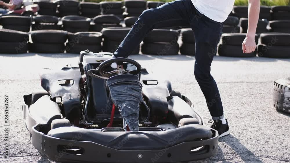 attractive man sititng in a gocart on the track checkin all procedures before a race