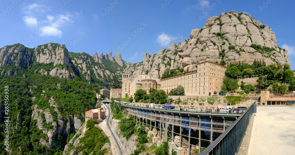 Montserrat / Spain - June 2018: View on Santa Maria de Montserrat Abbey and surrounding mountains from Eastern Angle on sunny day