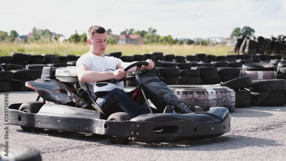 attractive man sititng in a gocart on the track checkin all procedures before a race