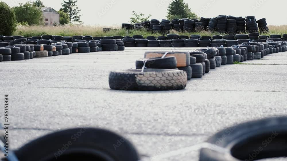 attractive male racer in protective helmet racing on the go-kart track outdoors