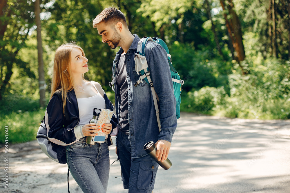 Tourists in a summer forest. Couple with a map. Tourists in a summer forest. Couple with a map.