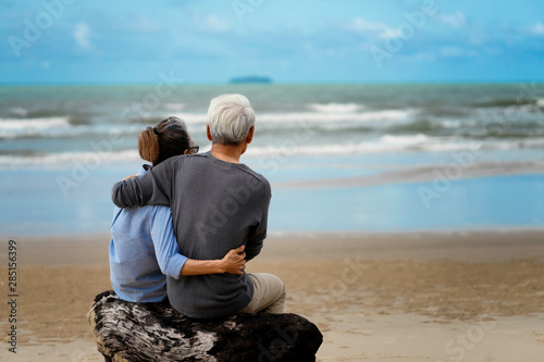 Life after retirement.Elderly life insurance.The old couple side by side until the old man.The elderly couple walk hand in hand on the beach to relax after long work.