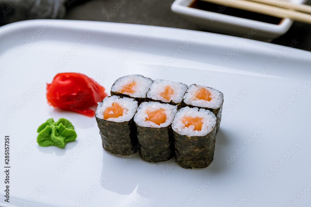 salmon roll on black concrete table salmon roll on black concrete table
