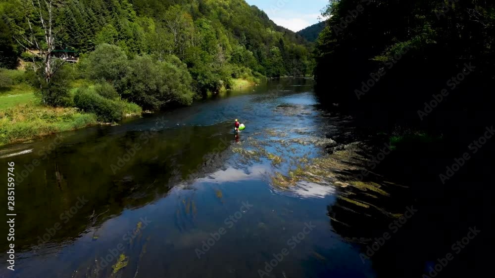 Man Dragging his Kayak Through a River Man Dragging his Kayak Through a River