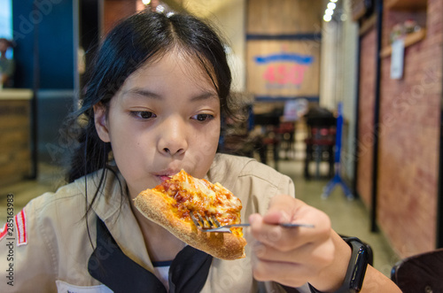 Asian children eat pizza