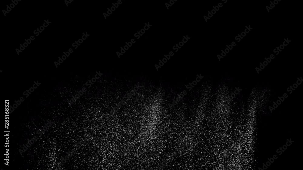 Long spray of particles spurt from side shot in studio filling frame 