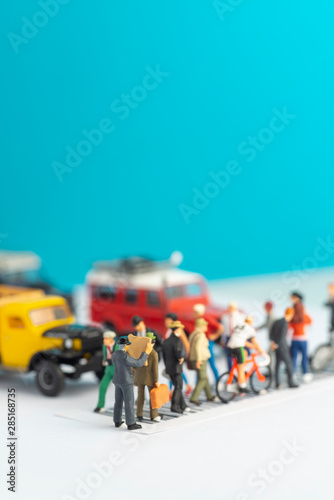 Miniature toys of a man reading newspaper, oblivious of his surrounding while crossing a street, reading habit concept.