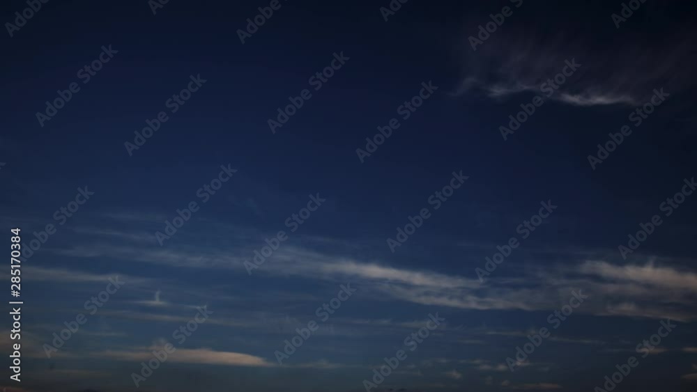 Day to night timelapse with clouds moving fast on blue sky during sunset