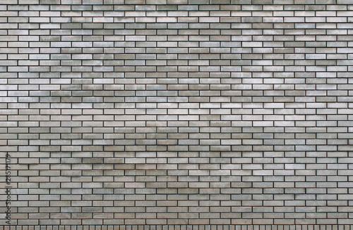 Old grey brick wall texture background. Tiled.