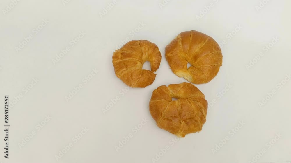 Overhead shot of a three fresh croissants on the white background in 4K. Overhead shot of a three fresh croissants on the white background in 4K.