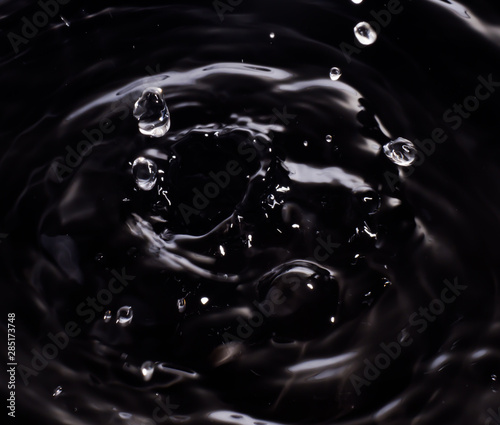 Motion dripping water black background.