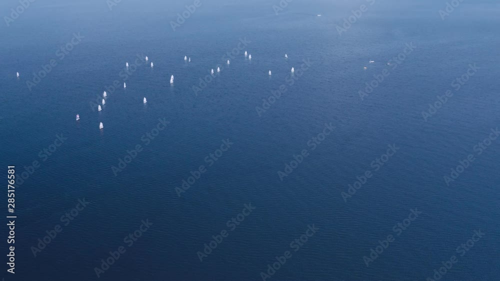 Lot of sailing yachts sail open sea oceans. Sport navigation regatta competition. Freedom extreme tour. Associated wind blue water horizon. Aerial Drone Top Lot of sailing yachts sail open sea oceans. Sport navigation regatta competition. Freedom extreme tour. Associated wind blue water horizon. Aerial Drone Top