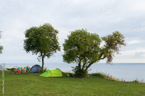 Tents and bikes under two trees an early morning on the island of Ven in southern Sweden