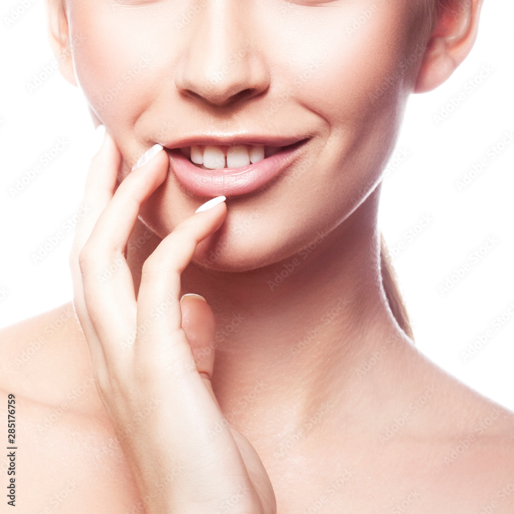 Beauty partial face, model woman applying cream on her face, perfect skin, happy smile, natural nude makeup. Facial treatment concept