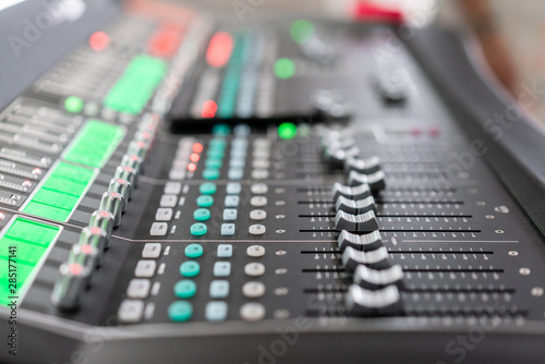 od adjusters and red buttons of a mixing console. It is used for audio signals modifications to achieve the desired output. Applied in recording studios, broadcasting, television.