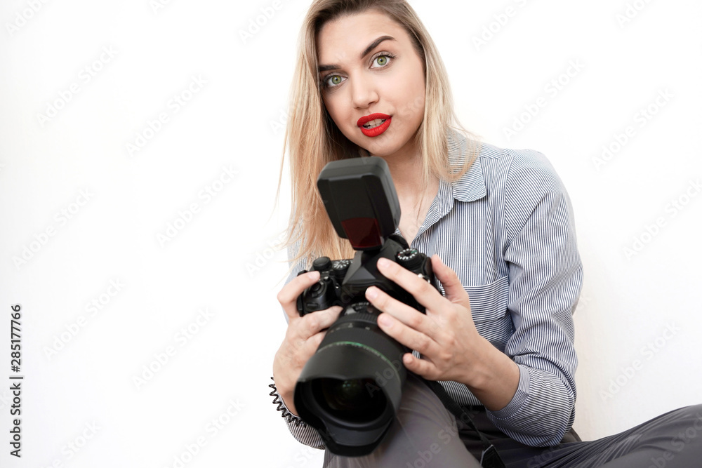 Beautiful young blonde with a big camera looks into the camera, toning Beautiful young blonde with a big camera looks into the camera, toning