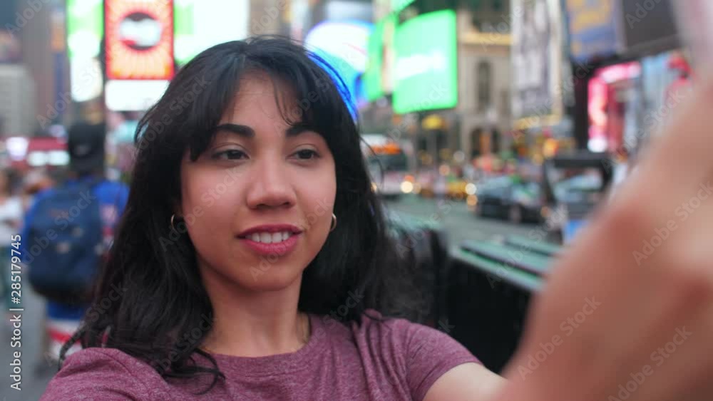 A young Latina woman takes selfies in Times Sq. A young Latina woman takes selfies in Times Sq.