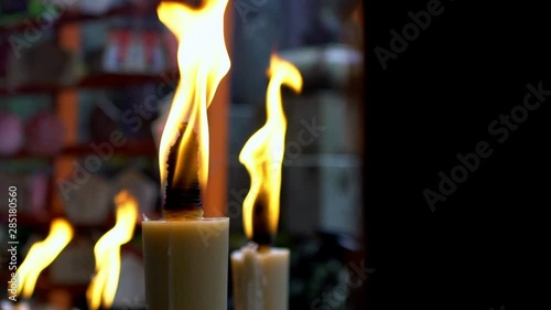 Slow Motion of candles burning in small temple at famous grounds of Fushimi Inari Taisha shrine in Kyoto. The candle flame that people raised for worship in Japan sanctuary.-Dan photo