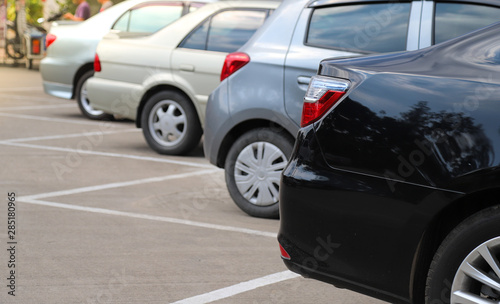 Closeup of rear side or back side of black car and other cars parking in outdoor parking area. © Amphon
